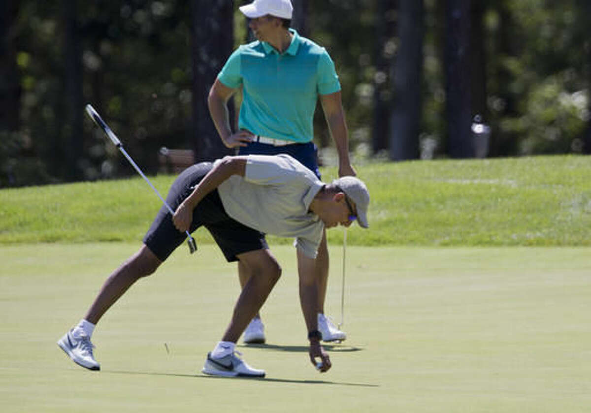 President Barack Obama picks up his ball after putting on the first green during a round of golf at Farm Neck Golf Course in Oak Bluffs, Mass., on Martha's Vineyard, Sunday, Aug. 7, 2016. The president and his family are vacationing in the Massachusetts island of Martha's Vineyard. (AP Photo/Manuel Balce Ceneta)