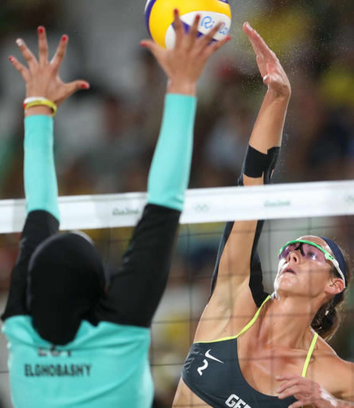 Germany's Kira Walkenhorst, right, tries to spike a ball past Egypt's Doaa Elghobashy, left, during a women's beach volleyball match at the 2016 Summer Olympics in Rio de Janeiro, Brazil, Sunday, Aug. 7, 2016. (AP Photo/Petr David Josek)