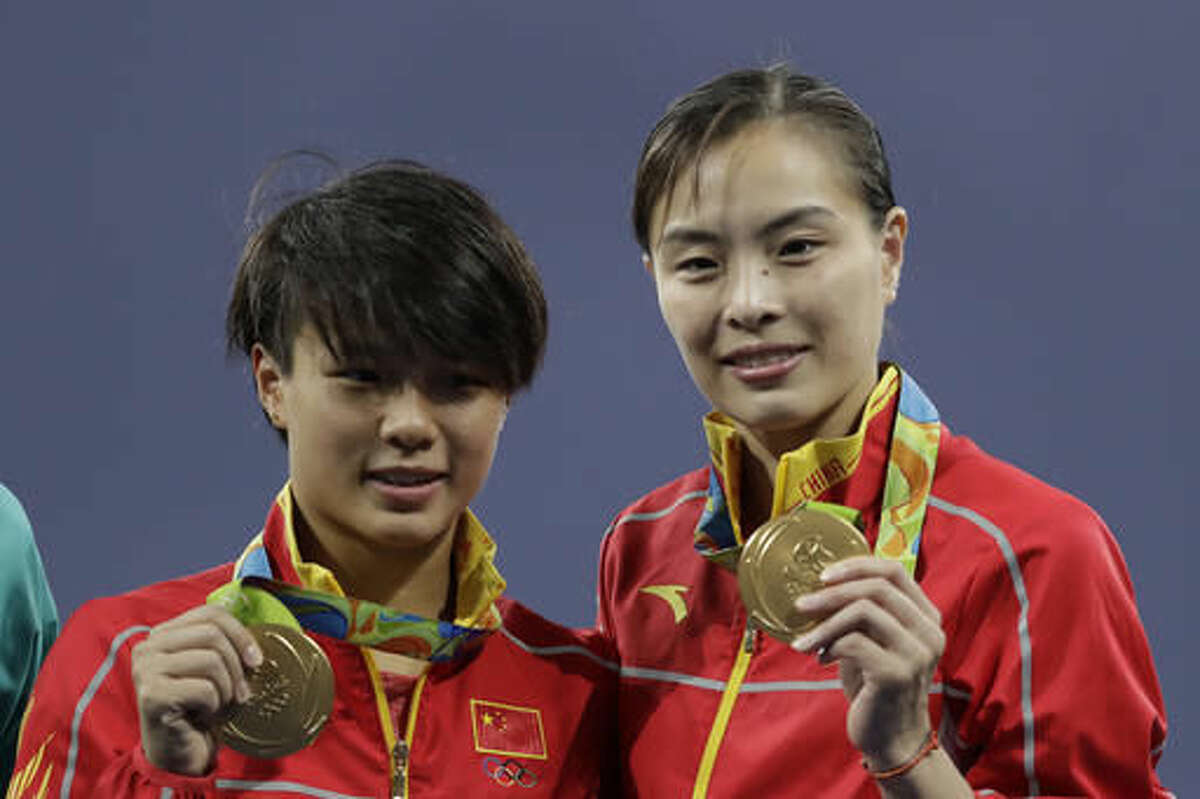 China's Shi Tingmao and Wu Minxia, right, pose with their gold medals after the women's synchronized 3-meter springboard diving final in the Maria Lenk Aquatic Center at the 2016 Summer Olympics in Rio de Janeiro, Brazil, Sunday, Aug. 7, 2016. (AP Photo/Matt Dunham)