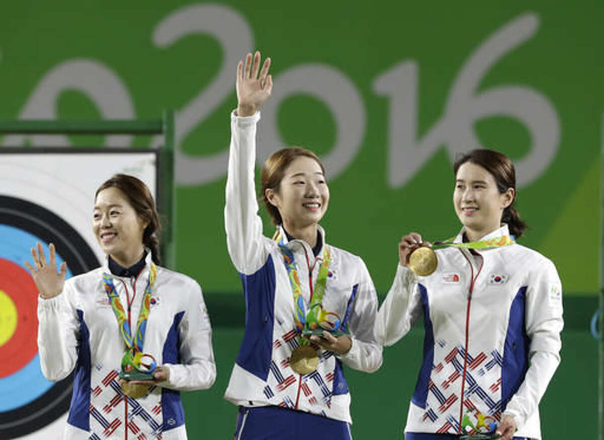 From left, South Korea's Chang Hye-jin, Choi Mi-sun and Ki Bo-bae celebrate their gold medals on the podium during the awards ceremony of the women's team archery competition at the Sambadrome venue during the 2016 Summer Olympics in Rio de Janeiro, Brazil, Sunday, Aug. 7, 2016. (AP Photo/Alessandra Tarantino)