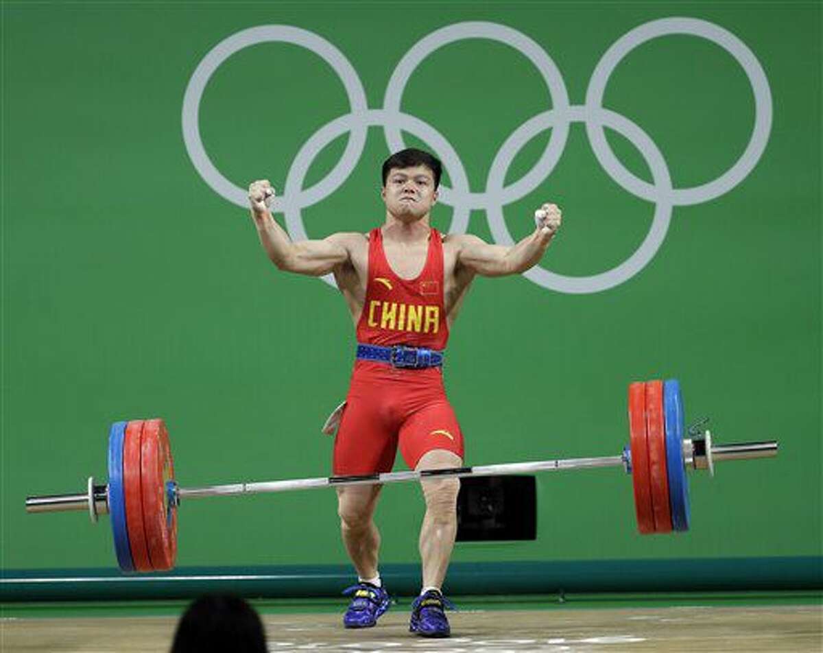 El chino Long Qingquan celebra un levantamiento exitoso en la competición de pesas, categoría de 56 kilogramos, de los Juegos Olímpicos en Río de Janeiro, el domingo 7 de agosto de 2016 (AP Foto/Mike Groll)