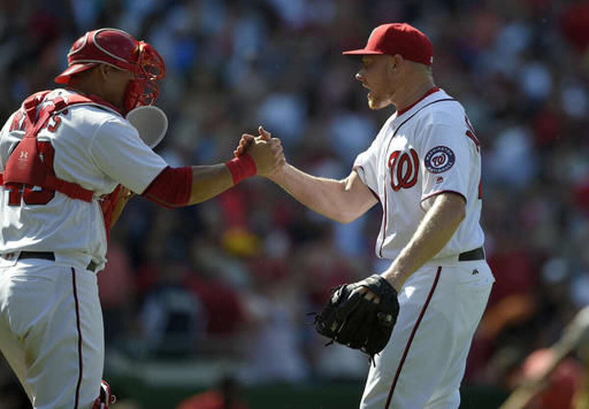 Washington Nationals relief pitcher Mark Melancon, right, celebrates a win over the San Francisco Giants with catcher Wilson Ramos, left, after a baseball game, Sunday, Aug. 7, 2016, in Washington. (AP Photo/Nick Wass)