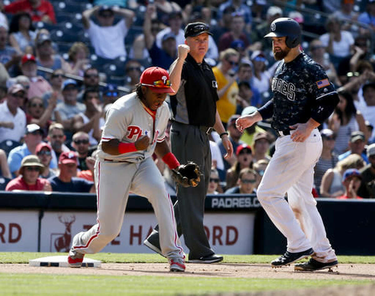 Philadelphia Phillies third baseman Maikel Franco, left, pumps his fist after a Phillies triple play against the San Diego Padres in the seventh inning of a baseball game Sunday, Aug. 7, 2016, in San Diego. Umpire Mike Everett, center, and Padres' Derek Norris, right, look on. (AP Photo/Lenny Ignelzi)