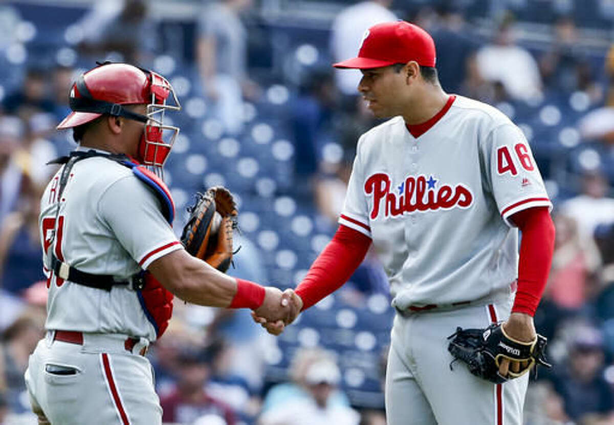 Philadelphia Phillies closer Jeanmar Gomez and catcher Carlos Ruiz congratulate each other after the Phillies' 6-5 victory over the San Diego Padres in a baseball game, Sunday, Aug. 7, 2016, in San Diego. (AP Photo/Lenny Ignelzi)