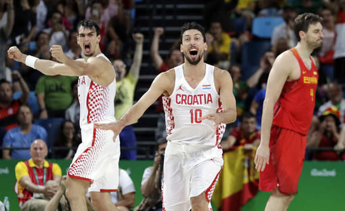 Croatia's Roko Ukic (10) and Dario Saric, left, celebrate after Spain's Pau Gasol, right, failed to make the final shots and Croatia upset Spain in a men's basketball game at the 2016 Summer Olympics in Rio de Janeiro, Brazil, Sunday, Aug. 7, 2016. (AP Photo/Eric Gay)