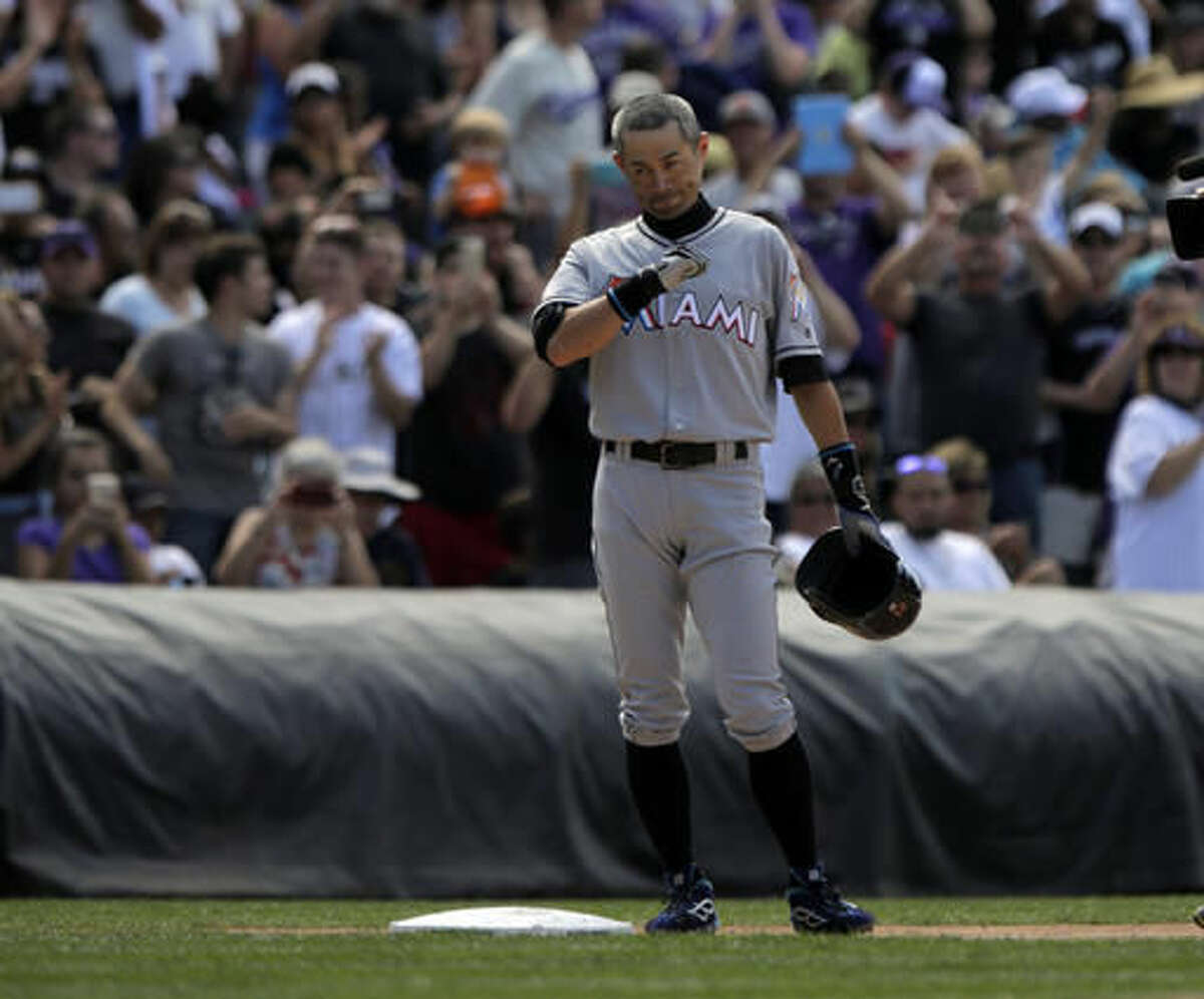 Miami Marlins' Ichiro Suzuki (51) tap his chest while acknowledging the crowd after he hit a triple for the 3,000th hit of his Major League Career in the seventh inning of a baseball game against the Colorado Rockies in Denver on Sunday, Aug. 7, 2016. (AP Photo/Joe Mahoney)