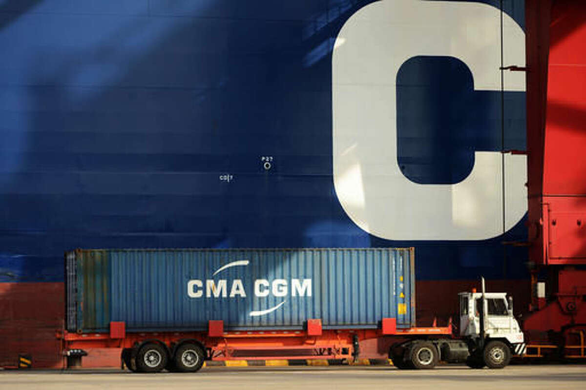 A cargo truck drives past a container ship at a port in Qingdao in eastern China's Shandong province Monday, Aug. 8, 2016. China's exports fell again in July by an unexpectedly wide margin while a decline in imports accelerated in a possible sign of weakness in the world's second-largest economy. (Chinatopix via AP)