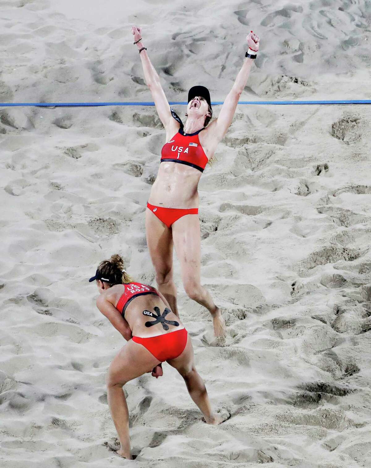 The United States' Kerri Walsh Jennings, top, and teammate April Ross celebrate after winning a point against Brazil's Larissa Franca and Talita Rocha during the women's beach volleyball bronze medal match at the 2016 Summer Olympics in Rio de Janeiro, Brazil, Wednesday, Aug. 17, 2016. (AP Photo/David Goldman)