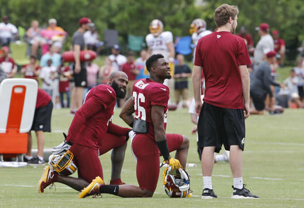 Washington Redskins DeAngelo Hall, left, and Bashaud Breeland, center, talk to a trainer during the afternoon practice at the Washington Redskins NFL football teams training camp in Richmond, Va., Friday, Aug. 5, 2016. (AP Photo/Steve Helber)