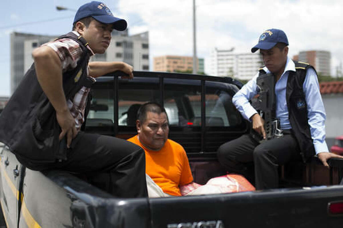 Santos Lopez Alonzo is escorted by Interpol agents after landing at the Air Force base in Guatemala City, Wednesday, Aug. 10, 2016. Lopez Alonzo, former Guatemalan soldier suspected of helping carry out a massacre of more than 160 people in 1982 during the country's civil war was deported from the United States on Wednesday after a court refused his plea to stay because he fears for his life. (AP Photo/Luis Soto)