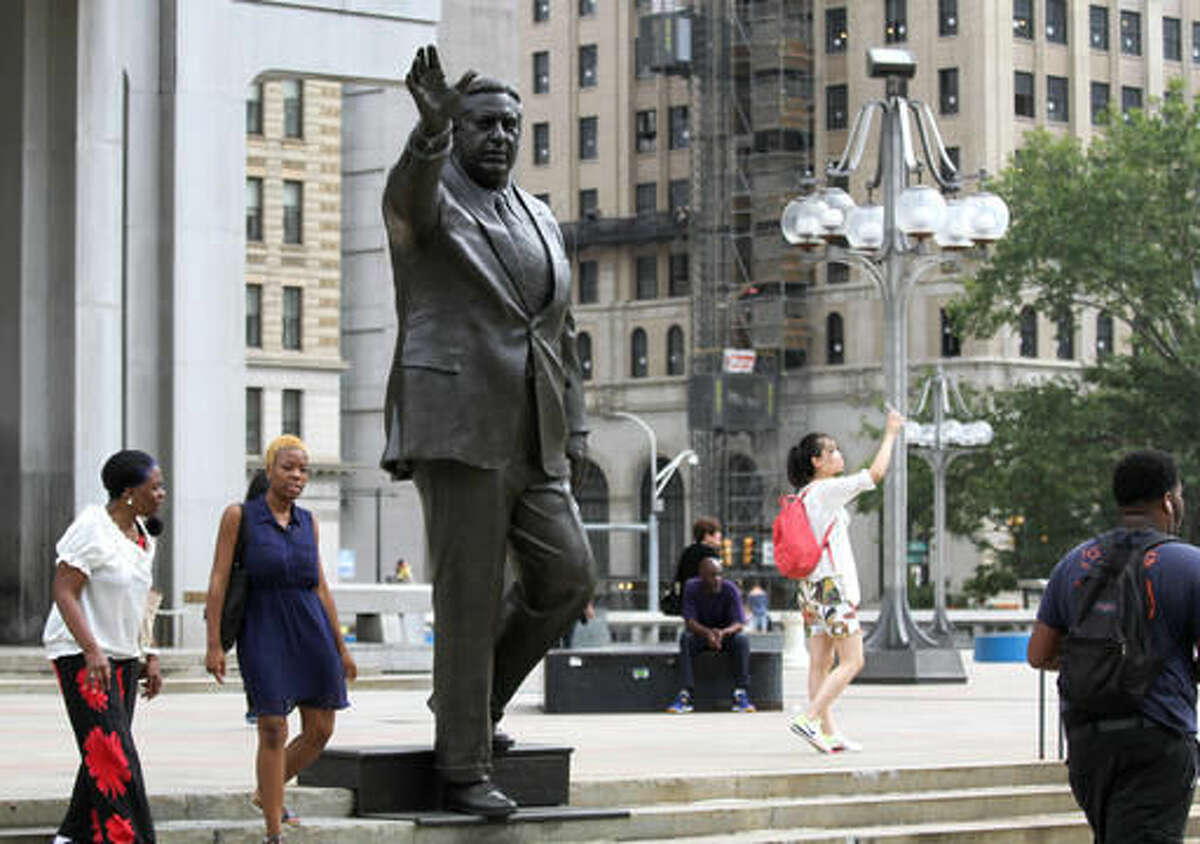 This Wednesday, Aug. 10, 2016, photo shows a statue of late Philadelphia Mayor Frank Rizzo, who also served as the city's police commissioner, on Thomas Paine Plaza outside the Municipal Services Building in Philadelphia. An anti-police brutality group, the Philly Coalition for REAL Justice, launched an online petition in August 2016 calling for the removal of the Frank Rizzo statue. (AP Photo/Dake Kang)