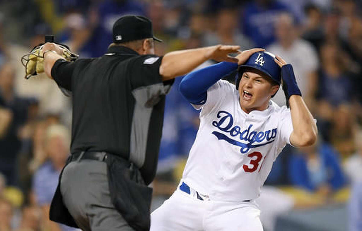 Los Angeles Dodgers' Joc Pederson, right, reacts after being called safe by home plate umpire Marvin Hudson, scoring on a single by Howie Kendrick during the second inning of a baseball game against the Pittsburgh Pirates, Friday, Aug. 12, 2016, in Los Angeles. (AP Photo/Mark J. Terrill)
