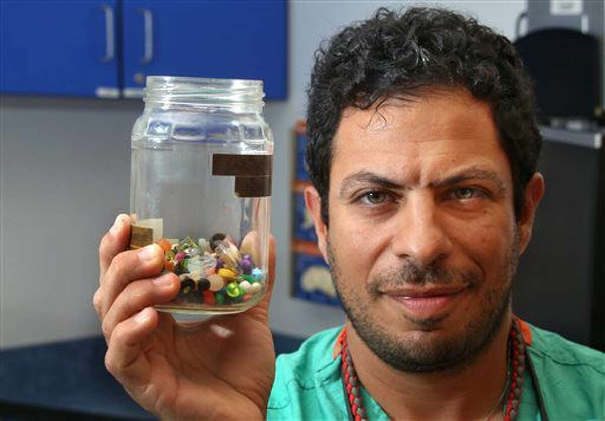 Charles Elmaraghy MD, Chief of the Ear, Nose and Throat Services at Nationwide Children's Hospital holds a collection of what children stuck in their ear, or up their nose on July 6, 2016 in Columbus, Ohio. From just the past couple of months, the jar contains dozens of beads, coins, pebbles and jewels. (Tom Dodge /The Columbus Dispatch via AP)