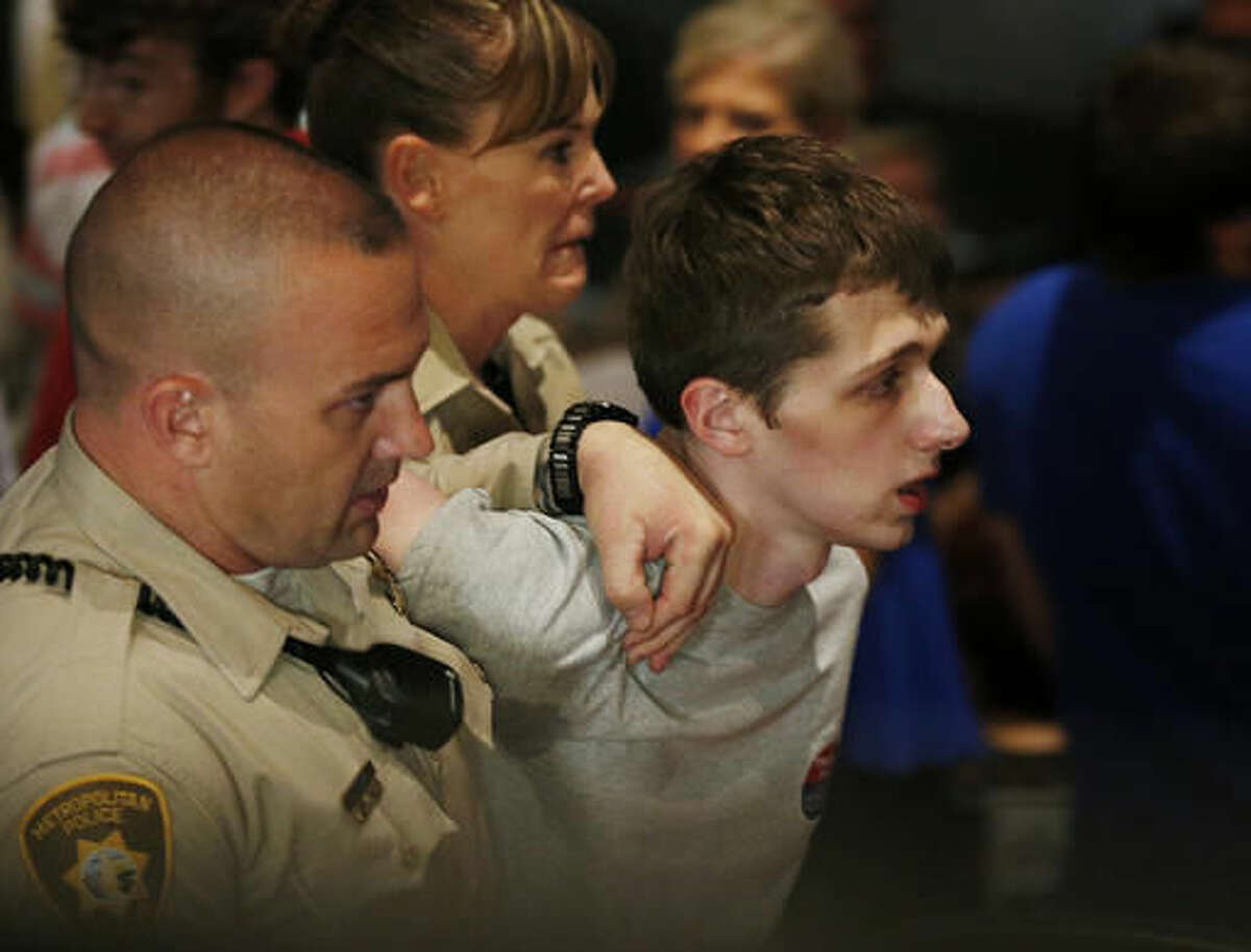 FILE - In this June 18, 2016, photo, police remove Michael Sandford as Republican presidential candidate Donald Trump speaks at the Treasure Island hotel and casino in Las Vegas. Sanford's mother is asking a U.S. judge to let her personally visit her son, who is jailed in Nevada after what authorities say was an an attempt to shoot Trump at a Las Vegas campaign rally. (AP Photo/John Locher, File)