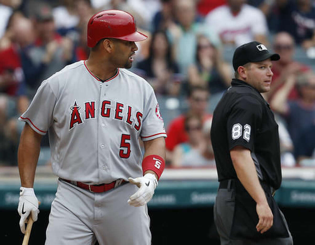 Los Angeles Angels' Albert Pujols, left, argues after being called out on strikes by home plate umpire Clint Fagan, right, during the eighth inning of a baseball game against the Cleveland Indians, Sunday, Aug. 14, 2016, in Cleveland. Pujols was ejected from the game. (AP Photo/Ron Schwane)