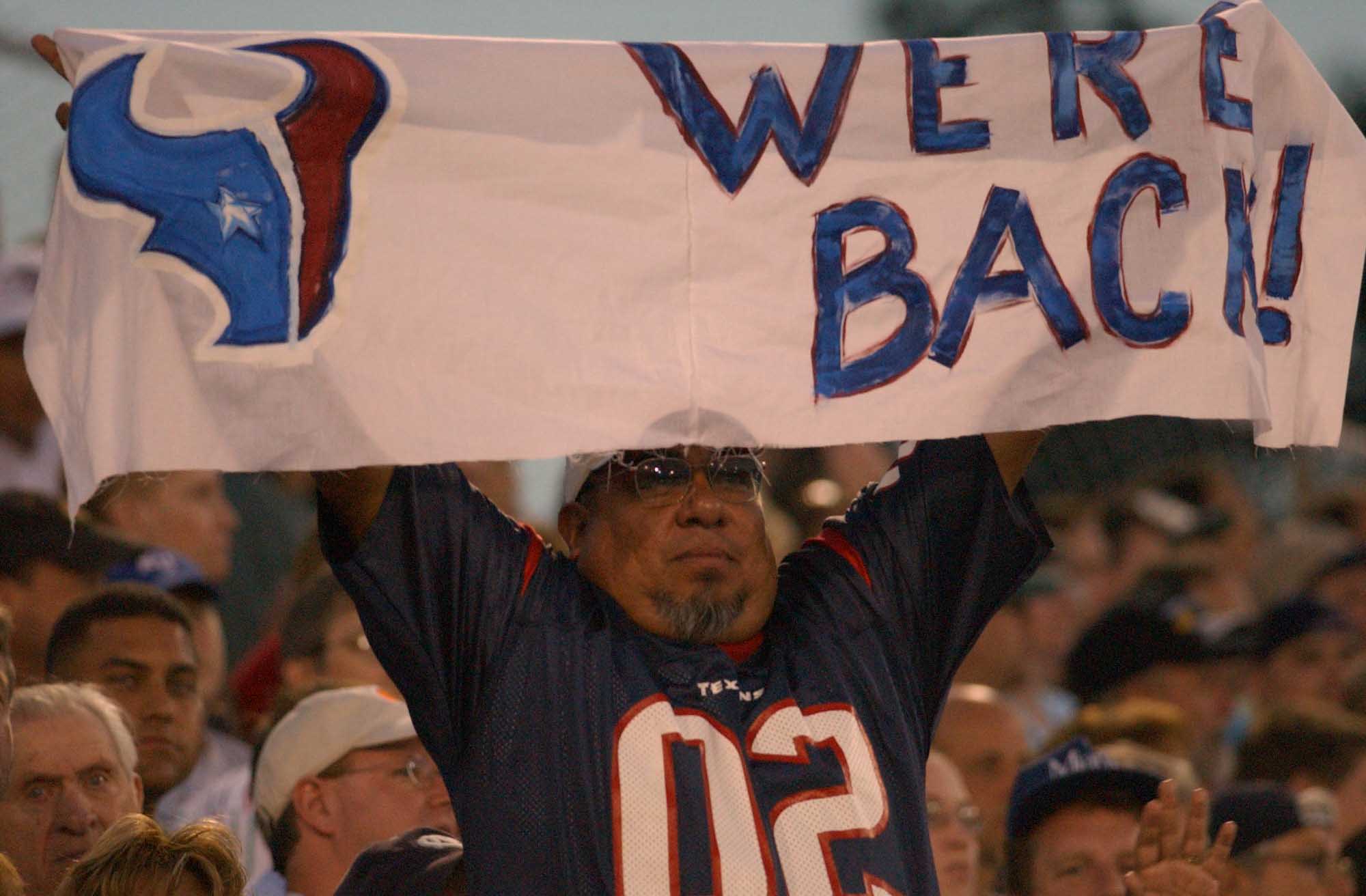 HOUSTON, TX - OCTOBER 30: Football fans hold up a Houston Oilers team flag  during the NFL game between the Tennessee Titans and Houston Texans on  October 30, 2022 at NRG Stadium