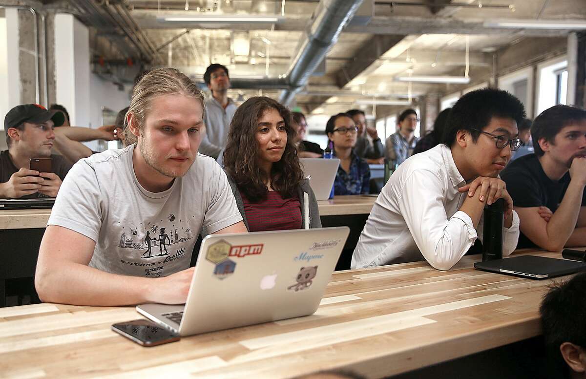 Students Christopher Pruijsen (left), Zohar Sanchez (middle), and Carl Chen (right) are some of the eighty students in their tenth month at Hack Reactor, a leading computer coding camp, listening to a lecture on Thursday, August 18, 2016, in San Francisco, Calif.