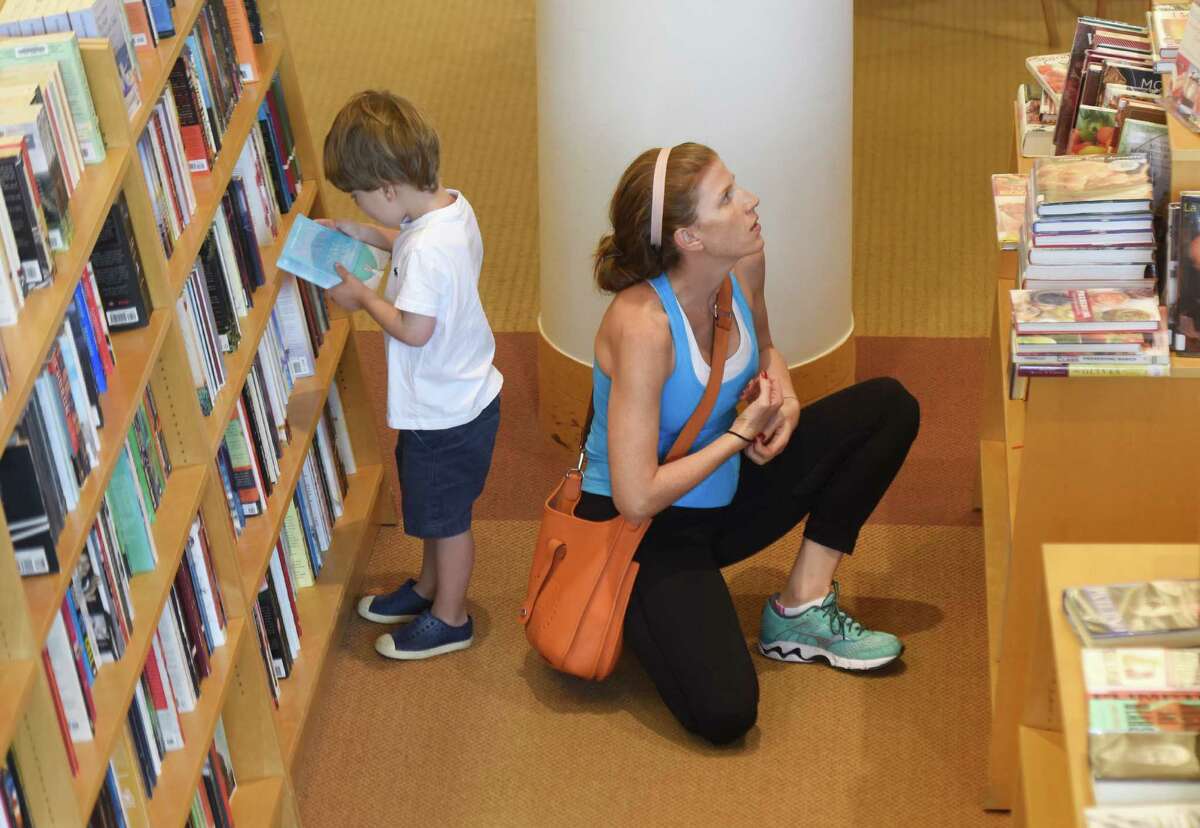 Dean, 3, and Stephanie Esquenazi, of Greenwich, browse the shelves for books at Greenwich Library in Greenwich, Conn. Thursday, Aug. 18, 2016.