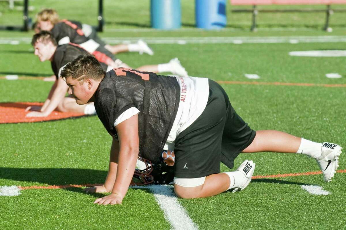 Matt Tarantino, a senior, doing leg stretches during a Ridgefield High School football practice. Friday, Aug. 19, 2016