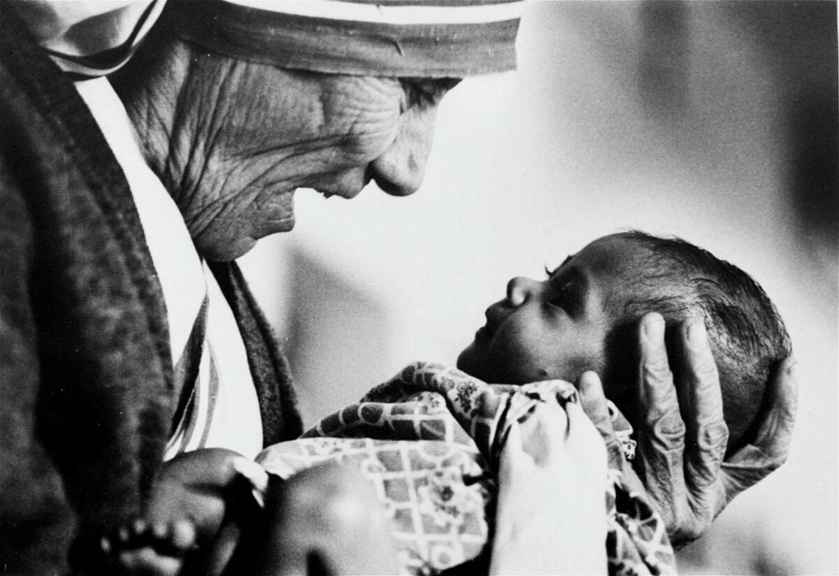 FILE - In this 1978, file photo, Mother Teresa, head of the Missionaries of Charity order, cradles an armless baby girl at her order's orphanage in what was then known as Calcutta, India, in 1978. Pope Francis has signed off on the miracle needed to make Mother Teresa a saint, giving the nun who cared for the poorest of the poor one of the Catholic Church's highest honors just two decades after her death. The Vatican said Friday, Dec. 18, 2015, that Francis approved a decree attributing a miracle to Mother Teresa's intercession during an audience with the head of the Vatican's saint-making office on Thursday, his 79th birthday. (AP Photo/Eddie Adams, File)