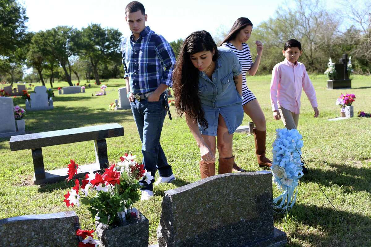 Denise Cantu, 36, center, and her family visit the gravesite of her children, Annissa Marie Salazar and Johnathon Dominic Cortez at the Monte Meta Cemetery near San Benito in January. The two children were killed in an auto accident in 2010 near Pleasanton after their vehicle lost its right year a tire in their vehicle blew out. She invested proceeds from an insurance settlement from that accident with San Antonio frac sand company FWLL LLC, doing business as FourWinds Logistics. FourWinds lost her investment and she had sued the company before it filed for bankruptcy. Her son was 5 years old and her daughter was 14 years old at the time of their death. With Cantu are her fiancée, Andrew Reyna (left), 27, and her daughter, Jasmin Conde, 15, and son, Ryan Yanez, 11.