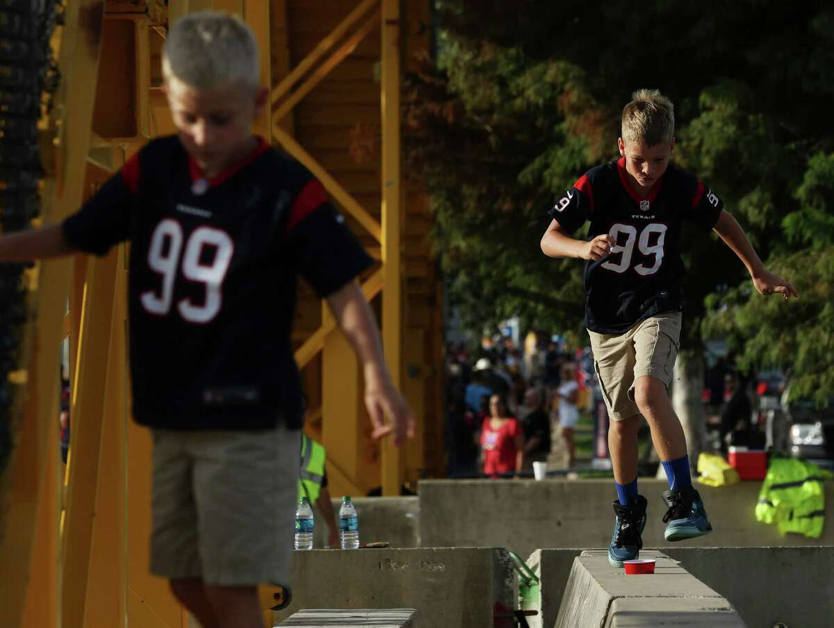 Two kids play at the parking lot before the Houston Texans preseason game against the New Orleans Saints Saturday, Aug. 20, 2016, in Houston .