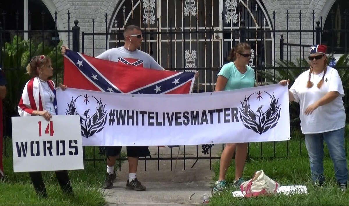 FILE - Protesters display a "White Lives Matter" sign in front of an NAACP office in Houston, Texas on Aug. 21, 2016. The label and associated persons were declared a "hate group" by the Southern Poverty Law Center shortly after.