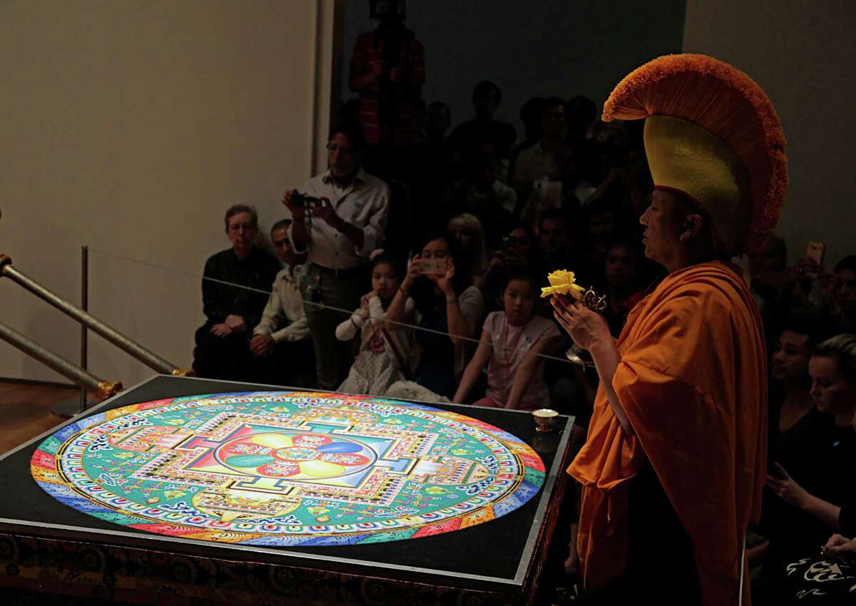 Geshe, Lobsang Rabjor during a ceremony by Tibetan Buddhist monks from Drepung Loseling Monastery to sweep away a mandala sand painting after millions of grains of sand are painstakingly laid into place in order to purify and heal the environment and its inhabitants at the Asia Society Texas Center Aug. 21, 2016, in Houston.