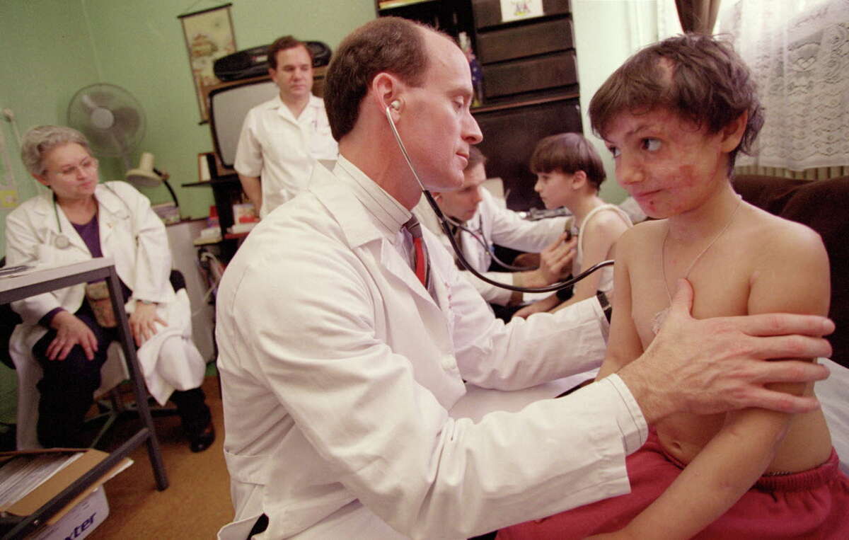 Dr. Mark Kline examines a patient in 1998 in Romania, where he would go on to found a pediatric AIDS clinic.