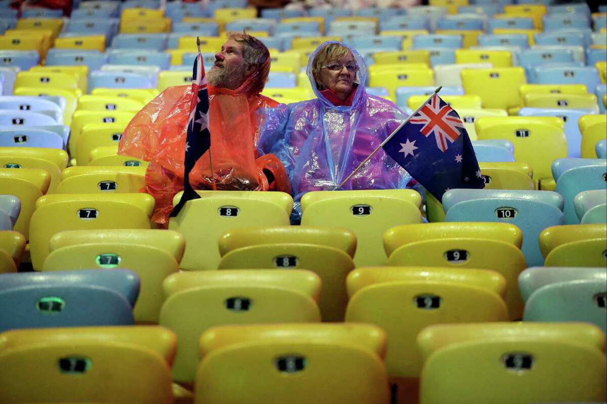Spectators wait in the rain for the start of the Summer Olympics closing ceremony inside Maracana stadium in Rio de Janeiro, Brazil, Sunday, Aug. 21, 2016.