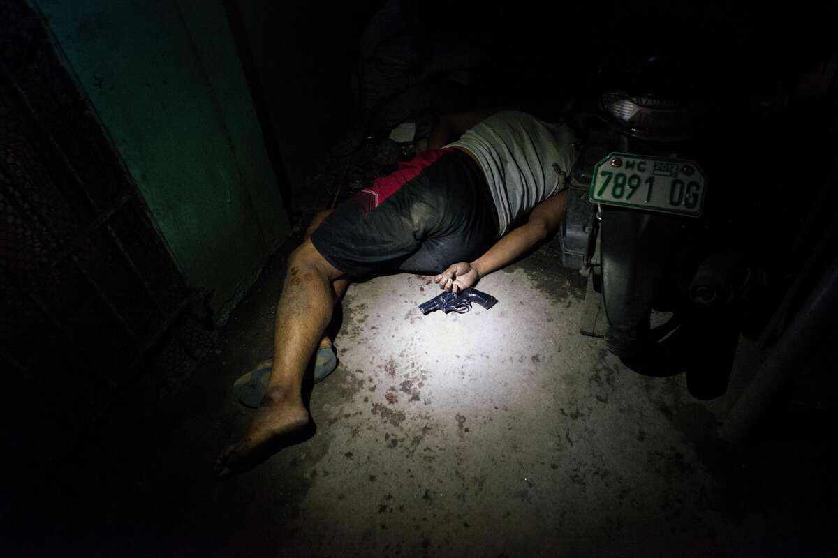 A drug suspect lies dead in a hallway during an alleged shootout with police on August 18, 2016 in Manila, Philippines. The death toll from the Philippines' war on drugs initiated by President Rodrigo Duterte has spiked to nearly 1,800 since he took office in June, a figure much higher than the 900 deaths previously cited by officials. International human rights advocates have condemned the killings as out of control and are calling on the government to end the nightly drug raids and investigate extrajudicial killings, although the president has lashed out at critics and threatened to withdraw from the United Nations. According to reports, investigations are still ongoing for 1,067 drug-related killings, reportedly carried out by vigilantes but it was unclear how many were directly related to the illegal drug trade.