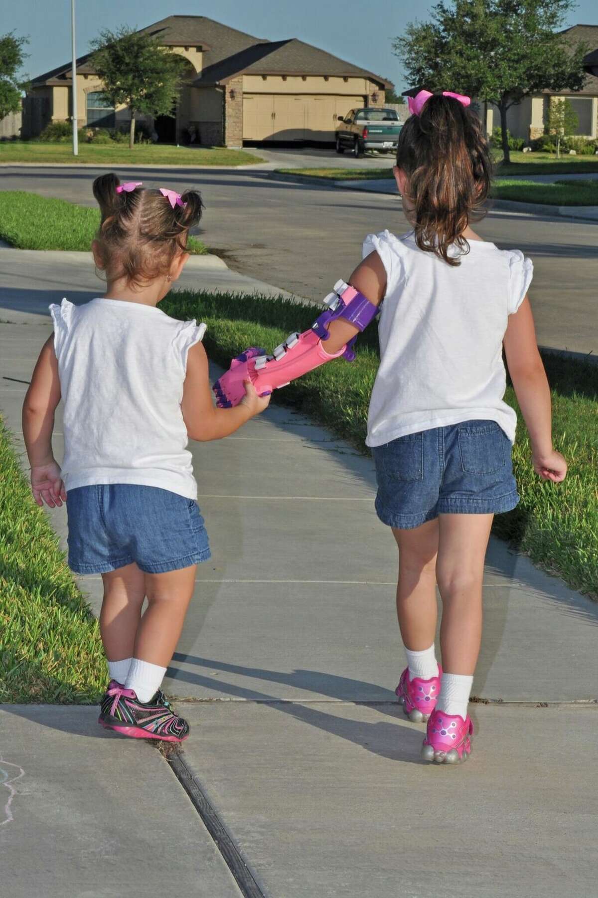 Katelyn Vincik, 5, of Victoria, received a prosthetic hand from the Clear Lake library, which used its 3D printer to make it. She is seen here walking with her sister Lacey. 3.