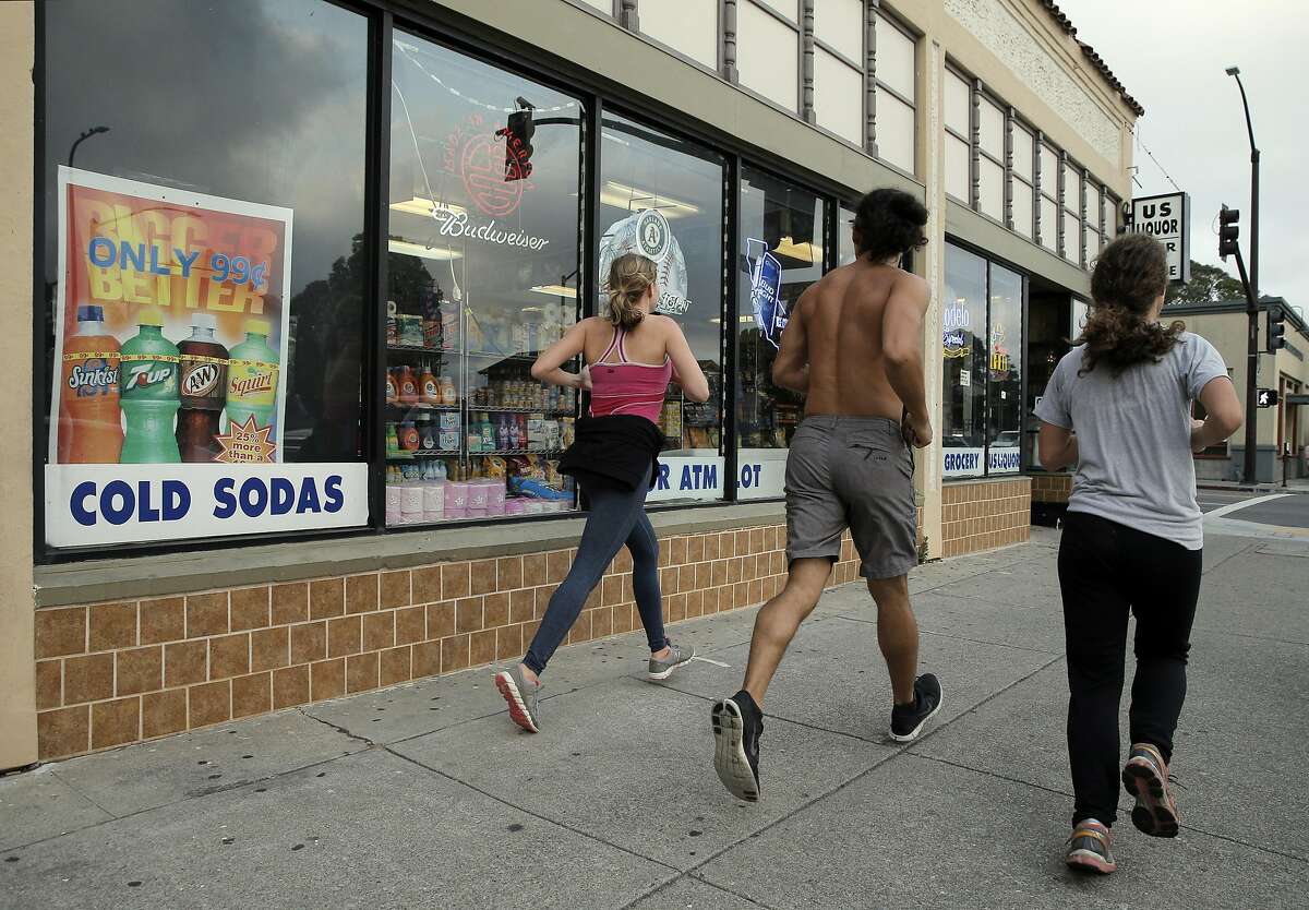 Joggers run by a sign advertising sodas for 99 cents at US Liquor Beer and Wine store in Berkeley, Calif., on Monday, August 22, 2016. A new UC-Berkeley study shows that Berkeley's first-of-its-kind-in-the-nation tax on sodas and other sugary drinks has led to a drop in soda consumption in the city's most low-income neighborhoods.