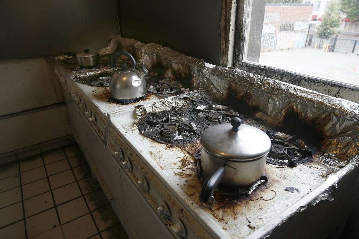 Tenants cook breakfast in the communal kitchen of a residential hotel on 8th Street in Oakland, Calif. on Tuesday, Aug. 23, 2016. The Oakland City Attorney is suing the owners of the building for intentionally demolishing sections of the building in an effort to drive out the low income tenants then spruce up the units to attract wealthier residents.