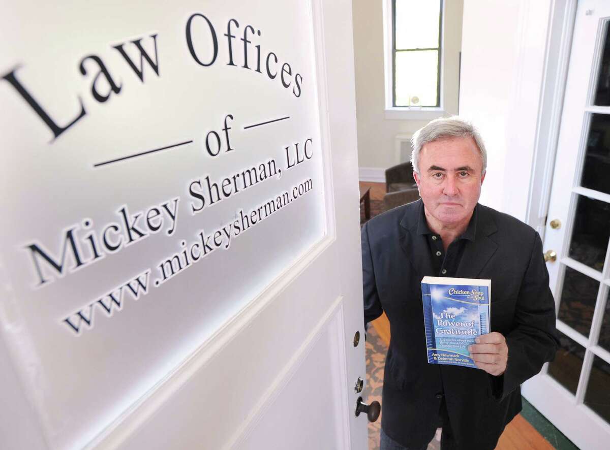 Attorney Mickey Sherman holds the book “Chicken Soup for the Soul: The Power of Gratitude,” in his Greenwich office.