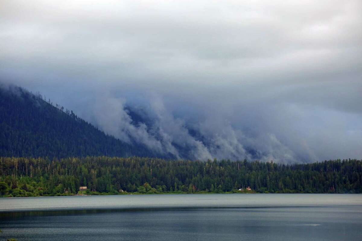 Clouds cascade down the flanks of the mountains surrounding Lake Quinault in the Olympic National Park.