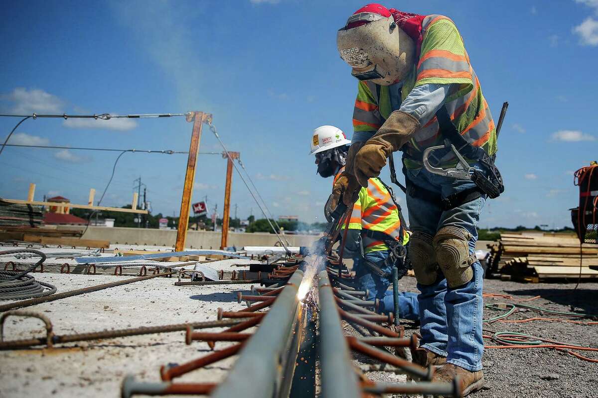 Crews weld a piece onto a bridge over Texas 36 as they work to widen U.S. 59 in Fort Bend County on Aug. 23 in Rosenberg. Expanding and rebuilding bridges is a major part of the 22-mile project.