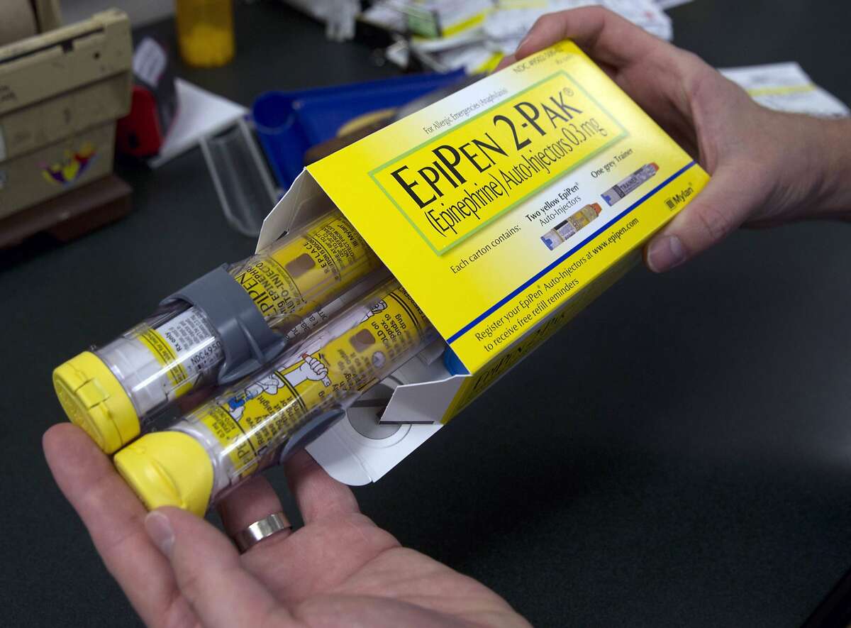 In this Friday, July 8, 2016 photo, a pharmacist holds a package of EpiPens, an epinephrine autoinjector for the treatment of allergic reactions, in Sacramento, Calif. Price hikes for the emergency medicine have made its maker, Mylan, the latest target for patients and politicians infuriated by soaring drug prices. (AP Photo/Rich Pedroncelli)