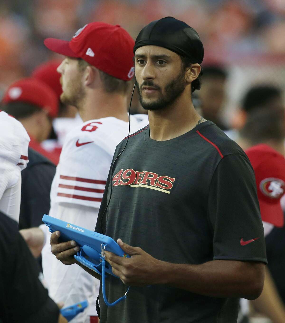 San Francisco 49ers quarterback Colin Kaepernick holds a tablet computer as he stands on the sideline during the first half of a preseason NFL football game against the Denver Broncos, Saturday, Aug. 20, 2016, in Denver. (AP Photo/Joe Mahoney)