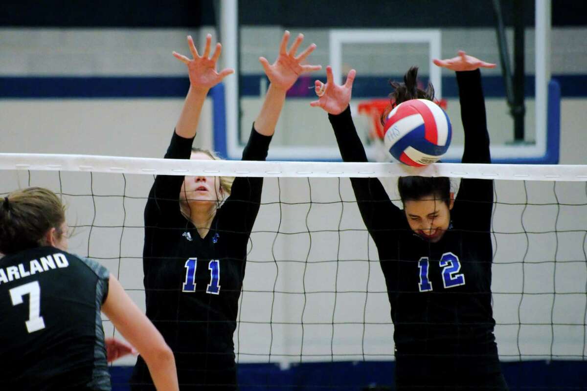 Friendswood's Faith Marabella (11) and Friendswood's Natalie Abowd (12) go high to block a shot by Pearland's Brooke Botkin (7) Tuesday, Aug. 23.