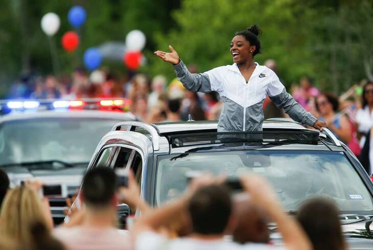Simone Biles treated fans to her trademark smile and energy during a welcome-home parade in Spring.