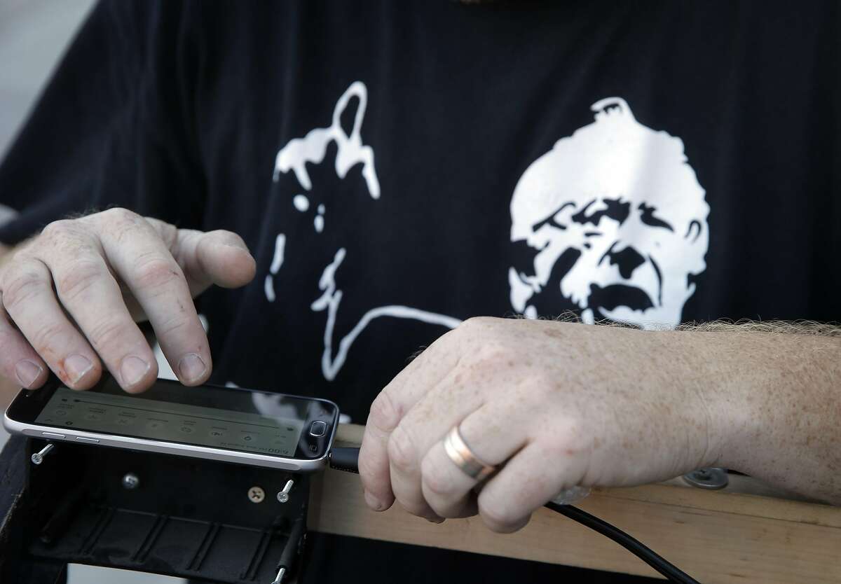 Event organizer, John Pomeroy checks the status of the live stream on his phone during a watch party the Soundwave Studios in Oakland, Calif., on Wednesday, August 24, 2016, where supporters listened to Bernie Sanders announcing in detail what the next step of his "political revolution."
