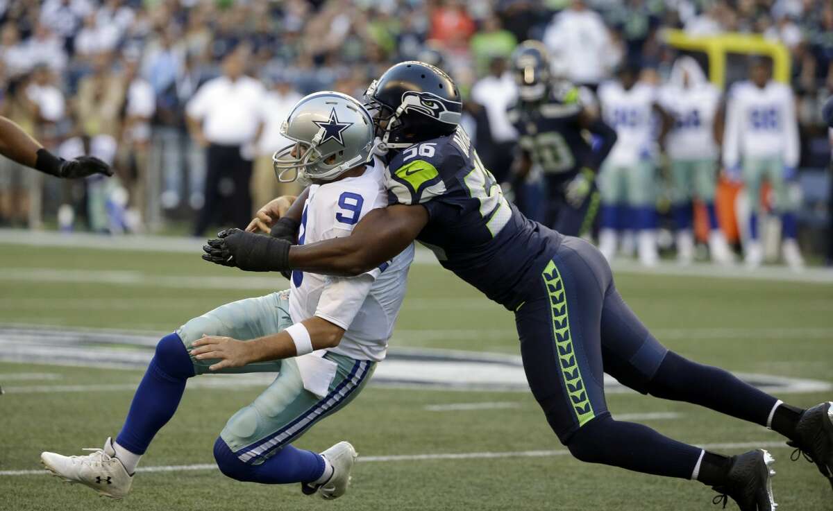 Dallas Cowboys quarterback Tony Romo, left, is tackled by Seattle Seahawks defensive end Cliff Avril, right, in the first half of a preseason NFL football game, Thursday, Aug. 25, 2016, in Seattle. (AP Photo/Elaine Thompson)