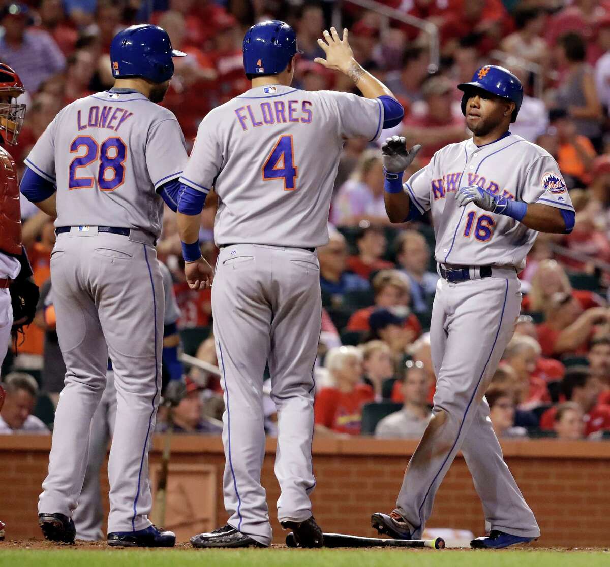 New York Mets' Alejandro De Aza, right, is congratulated by teammates James Loney (28) and Wilmer Flores (4) after hitting a three-run home run during the fifth inning of a baseball game against the St. Louis Cardinals Thursday, Aug. 25, 2016, in St. Louis. (AP Photo/Jeff Roberson) ORG XMIT: MOJR113