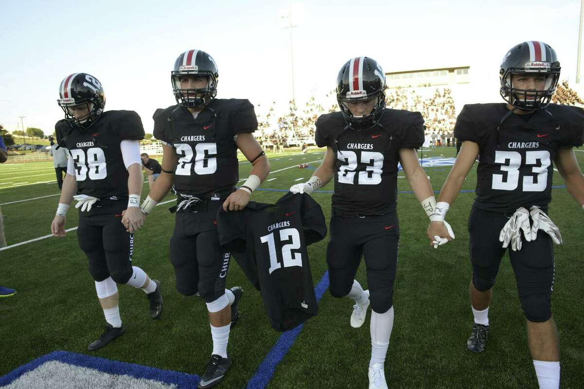 Churchill High School football team captains Tyler Ellis, left, Grant Gomez, Thomas Sharrick and Nicholas Sandoval carry the jersey of teammate Josh Pollard, who died recently from an unknown heart ailment, before the team's opening game against Clark High School in the annual Gucci Bowl at Commander Stadium on Aug. 25, 2016.