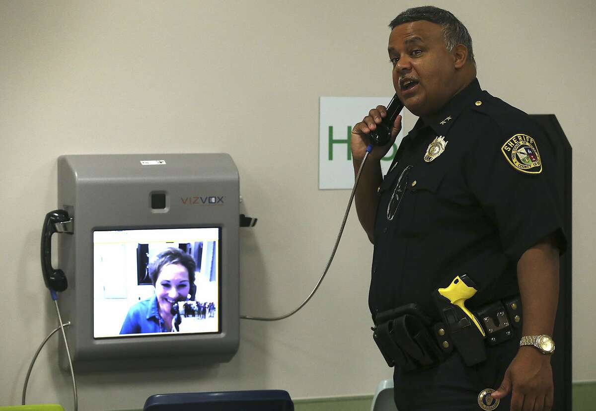 Bexar County Chief Jail Administrator Raul Banasco demonstrates a new video visitation system in August 2016. County employee Teresa Guerrero-Livengood is shown on the other end of the call.