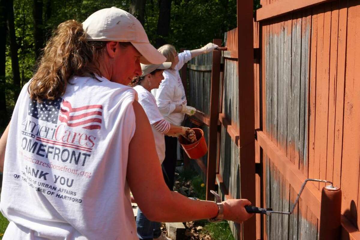 Church of the Good Shepherd volunteers, from left to right, Joyce Wilson, Antoinette Musante, and Bonnie Zabrocky paint a fence of a Seymour home as part of the 23rd annual HomeFront day on Saturday, May 1, 2010.