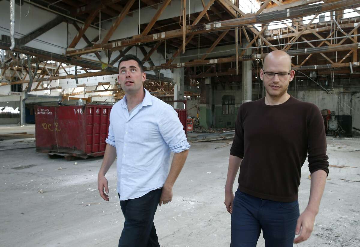 Danny Haber (left) and his business partner Yaniv Lushinsky discuss construction plans inside an abandoned warehouse at 1919 Market Street in Oakland, Calif. on Aug. 26, 2016, where their real estate development start-up firm Negev is building 63 live/work apartment units.