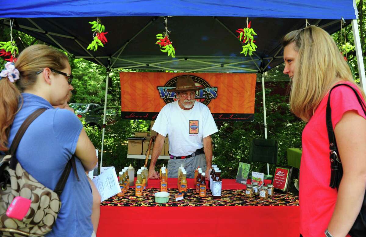 Vendor David Wanke tries to interest a customer in his hot sauce at Greenfield Hill Grange's annual Agricultural Fair on Hillside Road in Fairfield, Conn., on Saturday Aug. 27, 2016. There were farm and agricultural exhibits, grilled and baked goods, live poultry, games, a raffle, pony rides, live music, crafts and jewelry. Some of the exhibits and demonstrations included composting, square foot gardening, raising chickens and antique farm tools.