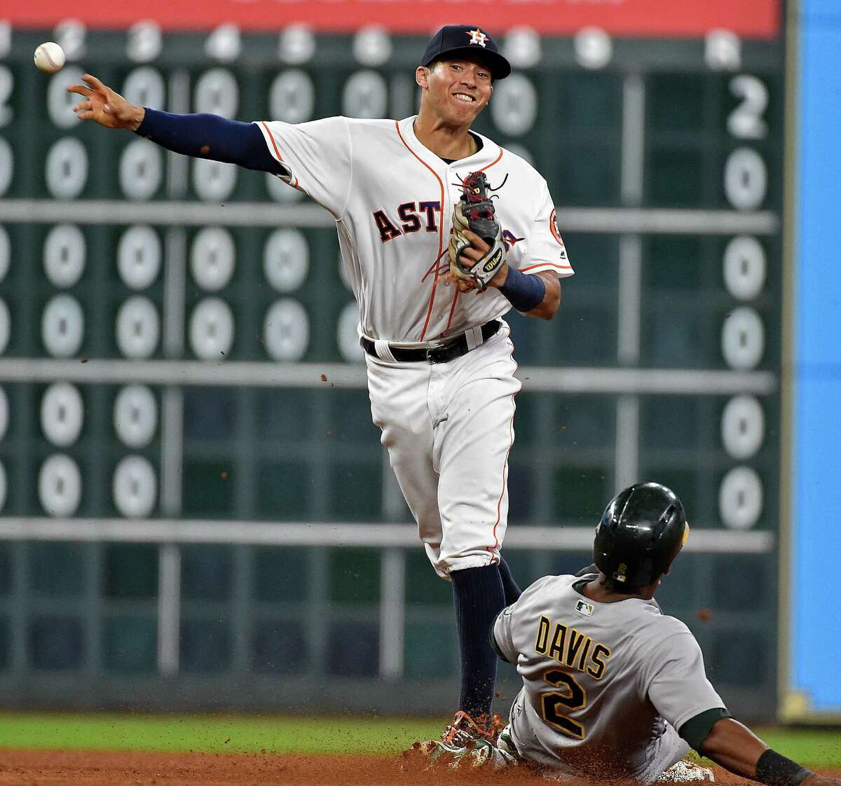 Houston Astros shortstop Carlos Correa, left, turns a double play over Oakland Athletics' Khris Davis to end the sixth inning of a baseball game, Monday, Aug. 29, 2016, in Houston. (AP Photo/Eric Christian Smith)